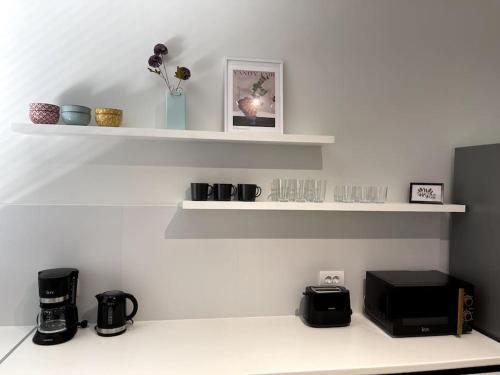 ナフプリオにあるBrand new in-town apartmentのキッチン(白い棚、電子レンジ付)