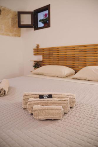 a pair of towels on a bed with a television at Bobboi in Cagliari