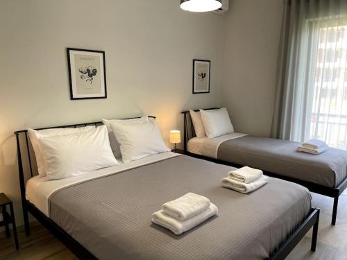 ナフプリオにあるBrand new in-town apartmentの部屋にはタオルが敷かれたベッドが2つある
