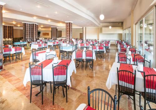 un ristorante con tavoli e sedie rossi e bianchi di Armas Pemar Beach a Kızılot