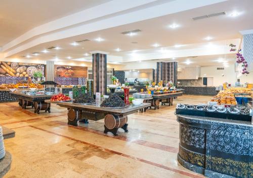 una mensa con tavoli pieni di frutta e verdura di Armas Pemar Beach a Kızılot