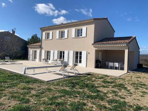 a house with two chairs in front of it at Les Collines de Saint-André in Saint-André-de-Cruzières