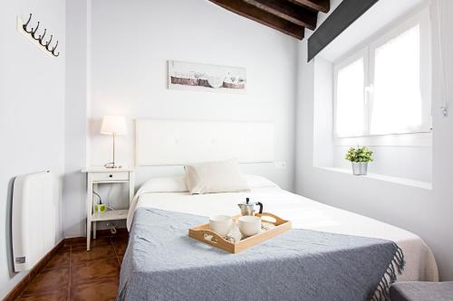 Dormitorio blanco con cama y bandeja en Granada FreshApartments by Bossh! Apartments, en Málaga