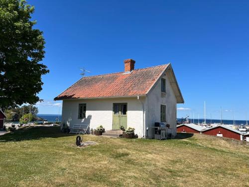 a white house with a dog sitting in front of it at Hamnstuga i Hästholmens småbåtshamn in Ödeshög