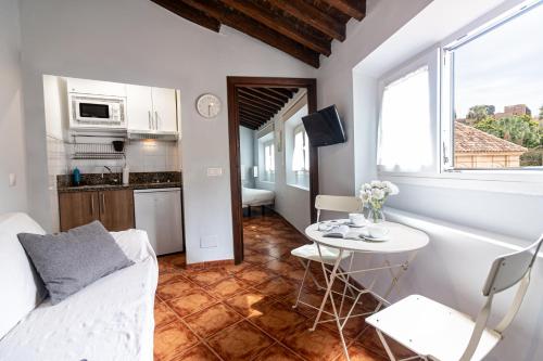 una pequeña sala de estar con un sofá blanco y una mesa. en Granada FreshApartments by Bossh! Apartments, en Málaga