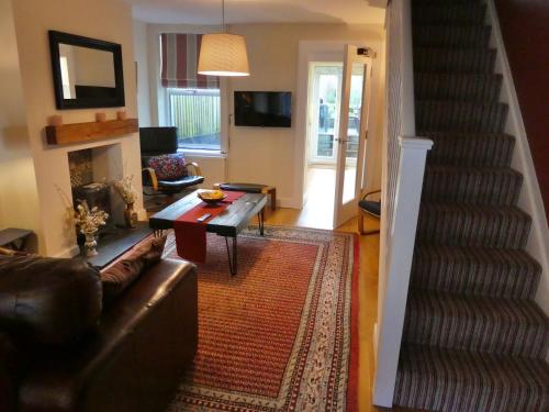 Chic 2-bedroom townhouse in vibrant Abergavenny في أبرجافني: غرفة معيشة مع أريكة وحقيبة درج