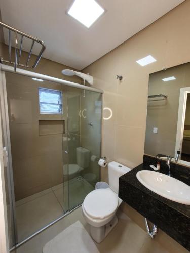a bathroom with a toilet and a shower and a sink at Avenida Palace Hotel in Joinville