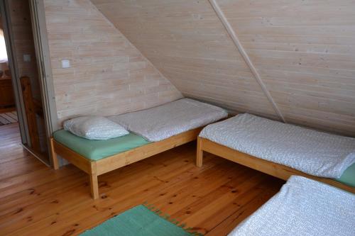 - une petite chambre avec 2 lits dans une maison dans l'établissement Domki nad Jeziorem Ołów, à Ryn
