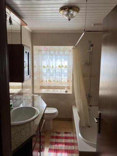 a bathroom with a sink and a toilet and a tub at Vistalinda Farmhouse in Fajã dos Vimes