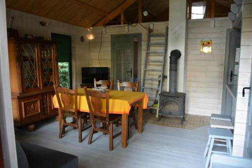 - une salle à manger avec une table et un poêle à bois dans l'établissement Domki nad Jeziorem Ołów, à Ryn