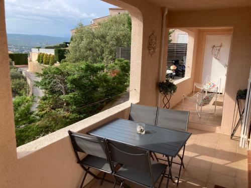 une table et des chaises sur le balcon d'une maison dans l'établissement La Madrague du Petit Prince vue mer époustouflante et jardin, à Saint-Cyr-sur-Mer