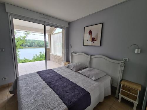 a bedroom with a bed and a view of the water at GITE DE CHARME in Changey