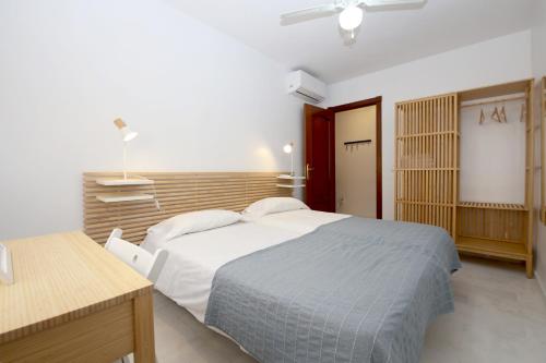 a bedroom with a large bed and a desk at Estepona Town Apartment CARMEN in Estepona