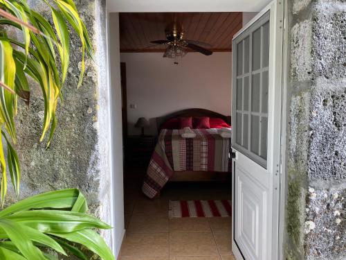 Una puerta que conduce a un dormitorio con cama en Vistalinda Farmhouse, en Fajã dos Vimes