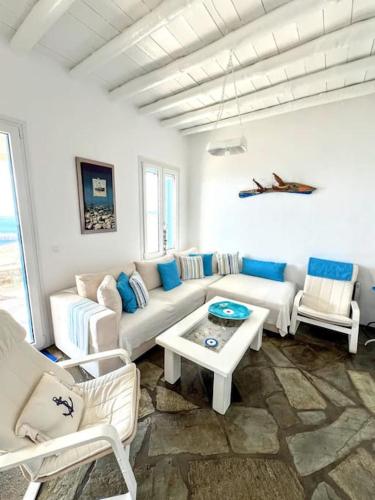 a living room with a couch and chairs and a table at Aggeliki's Cycladic Villa by Hostandros in Batsi