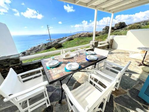 a table and chairs with a view of the ocean at Aggeliki's Cycladic Villa by Hostandros in Batsi