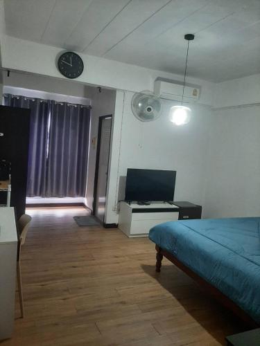 um quarto com uma cama e um relógio na parede em อพาร์ทเม้นท์บ้านสบาย em Phitsanulok