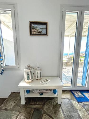 a white table with two appliances on it in a room with windows at Aggeliki's Cycladic Villa by Hostandros in Batsi