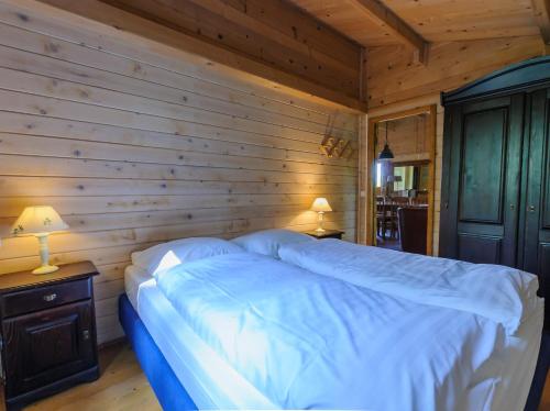 a bedroom with a bed with a wooden wall at Domaine de Maples in Dore-lʼÉglise