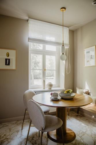 a dining room with a table and chairs and a window at Hotel Schloss Teutschenthal in Teutschenthal