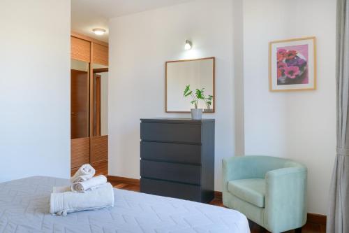 a bedroom with a bed and a blue chair at Suite Yagabo in Arrecife