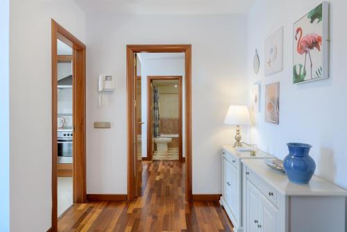 a bathroom with white walls and a wooden floor at Suite Yagabo in Arrecife