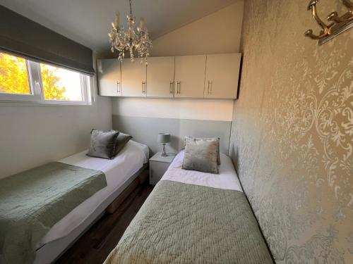a bedroom with two beds and a chandelier at Vakantie Villa Markermeer in Bovenkarspel
