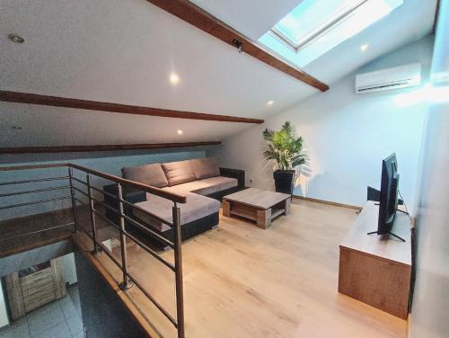 ein Wohnzimmer mit einem Sofa und einem TV in der Unterkunft Villa Greg in Saint-Marcel-lès-Valence