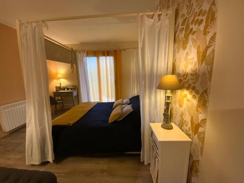 a bedroom with a blue bed with a canopy at Domaine de Labelo in Commensacq