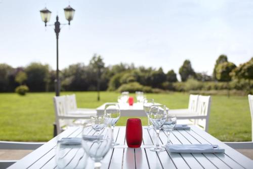 a white table with wine glasses and a red candle at nordica Hotel Berlin in Heide