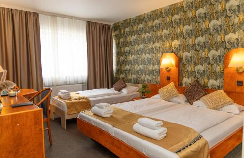 フランクフルト・アム・マインにあるホテル ロシヤのベッド2台とデスクが備わるホテルルームです。