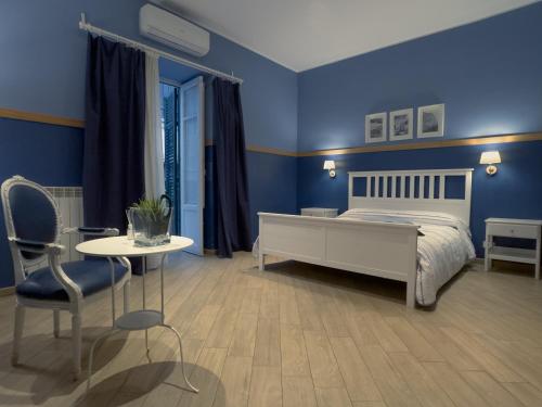 una camera blu con un letto e un tavolo con sedie di Novelli 36 a Palermo