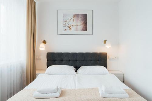 a bedroom with two beds and a picture on the wall at Hotel Logos in Warsaw