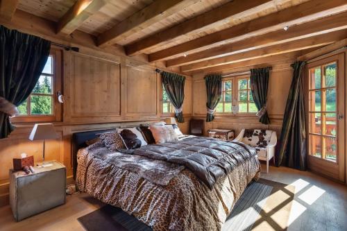 a bedroom with a large bed in a room with wooden walls at Chalet de 4 chambres avec jacuzzi terrasse et wifi a Megeve a 2 km des pistes in Megève