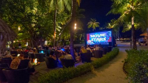 a crowd of people sitting in chairs in front of a screen at Kuredu Island Resort & Spa in Kuredu