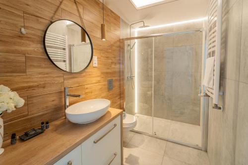 a bathroom with a sink and a shower with a mirror at Apartview Bukowa III by Rent like home in Wisła