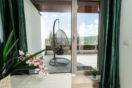 a room with a glass door and a swing at Apartview Bukowa III by Rent like home in Wisła