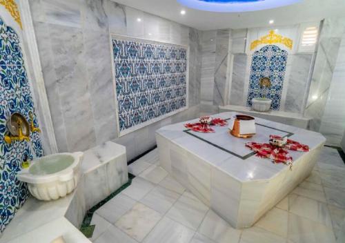 a bathroom with blue and white tiles and a tub at Armas Pemar Beach in Kızılot