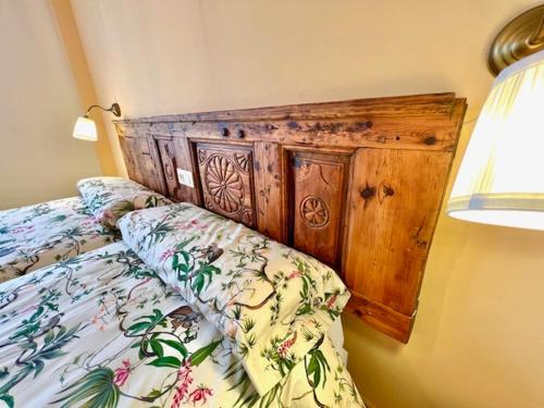 - un lit avec une tête de lit en bois dans une chambre dans l'établissement Navalpinar, à Navalmanzano