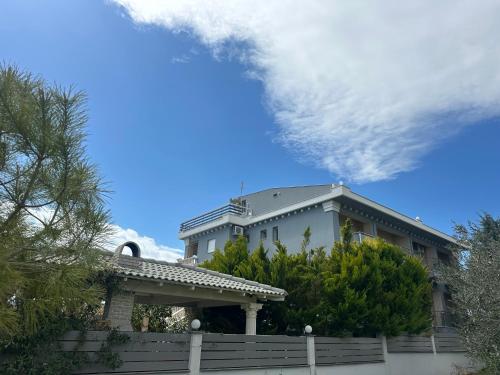 a white house with a fence in front of it at Villa Spartandom in Gerakini