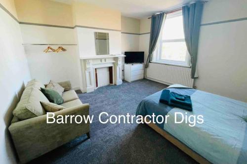 a bedroom with a bed and a couch and a fireplace at Barrow Contractor Digs, Serviced Accommodation, Home from Home in Barrow in Furness