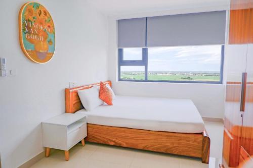 ein kleines Schlafzimmer mit einem Bett und einem Fenster in der Unterkunft Tim Homestay Nera Garden in Hue