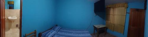 een blauwe kamer met een bed in de hoek bij Shania in Trujillo