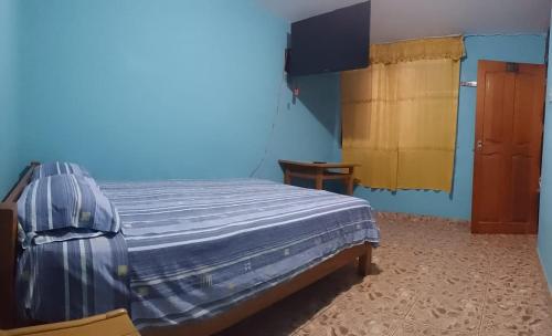 1 dormitorio con 1 cama en una habitación azul en Shania en Trujillo