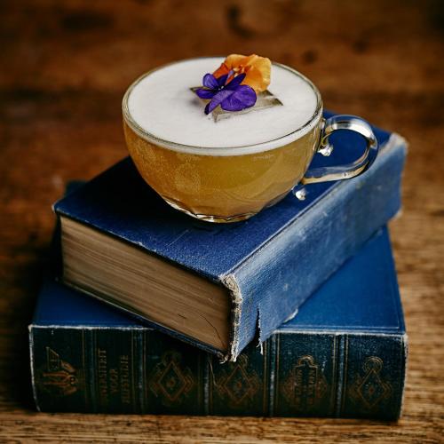 a cup of coffee sitting on top of two books at INK Hotel Amsterdam - MGallery Collection in Amsterdam