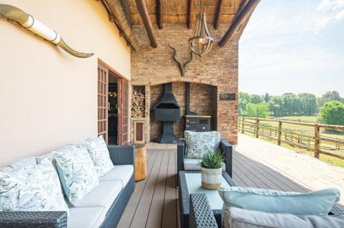 an outdoor living room with a couch and a fireplace at Whispering Waters in Fort Nottingham