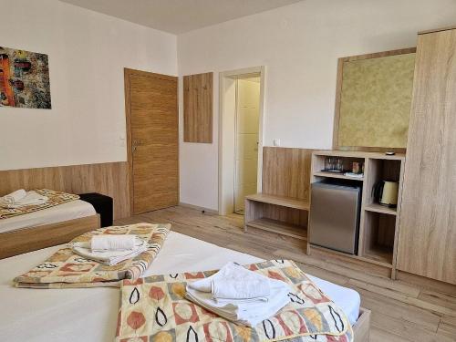 a hotel room with two beds and a kitchen at Apartment and Rooms Amenka in Novalja