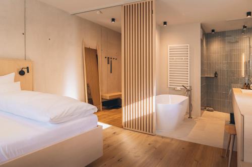 a bedroom with a bed and a tub in a bathroom at Haus Jausern in Saalbach Hinterglemm