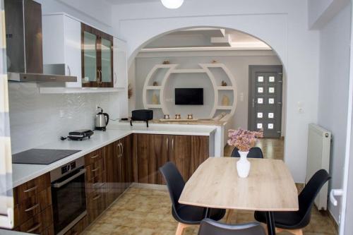 ピタゴリオにあるSpacious Apartment in the heart of Pythagorionのテーブルと椅子付きのキッチン、アーチ付きのキッチン