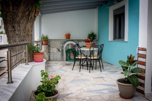 un patio con mesa, sillas y un árbol en Spacious Apartment in the heart of Pythagorion en Pythagóreion